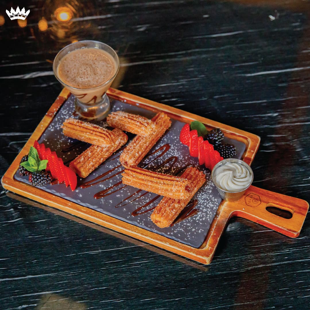 Dulce de leche churros with chocolate drizzle, fresh strawberries, and house made whipped cream.