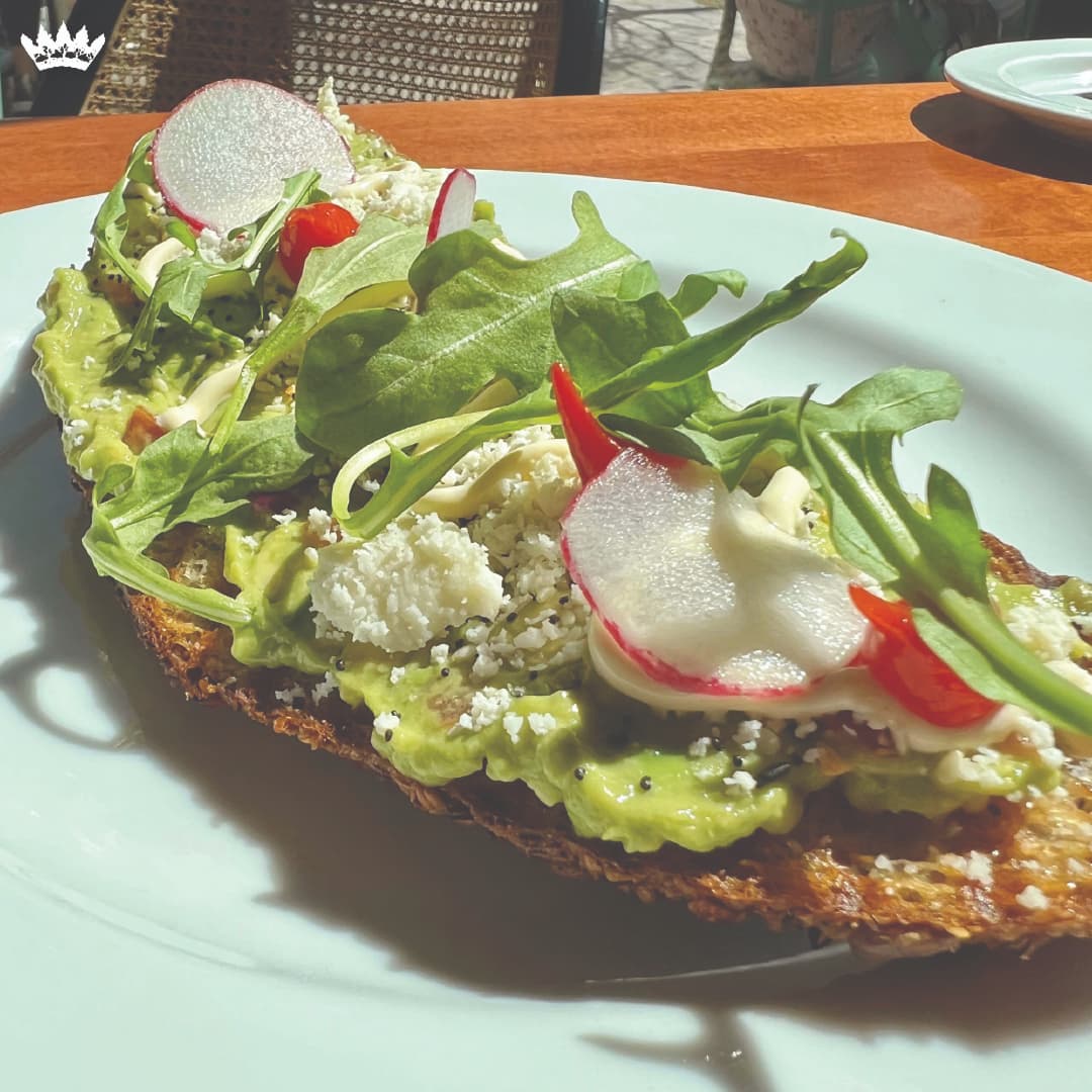Sola avocado toast topped with radish, micro arugula, everything seasoning, queso fresco, and sweet drop peppers.