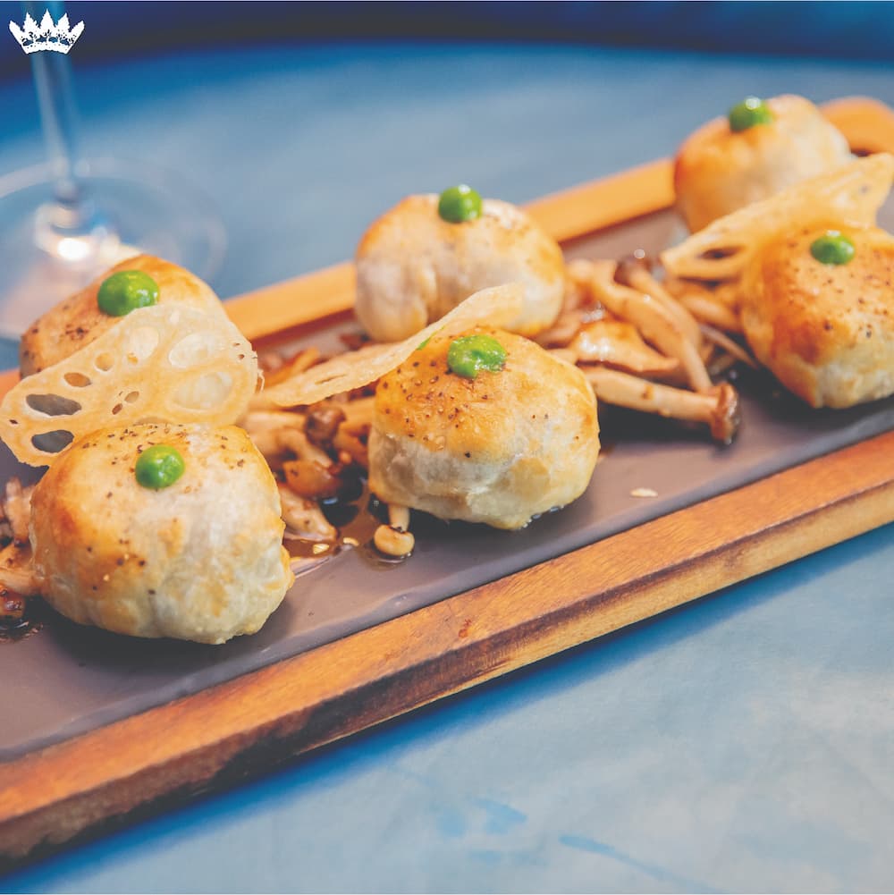 The Grove Wellingtons, filet and Boursin with mushroom duxelles in flaky pastry, served over wild foraged mushrooms with demi-glace.